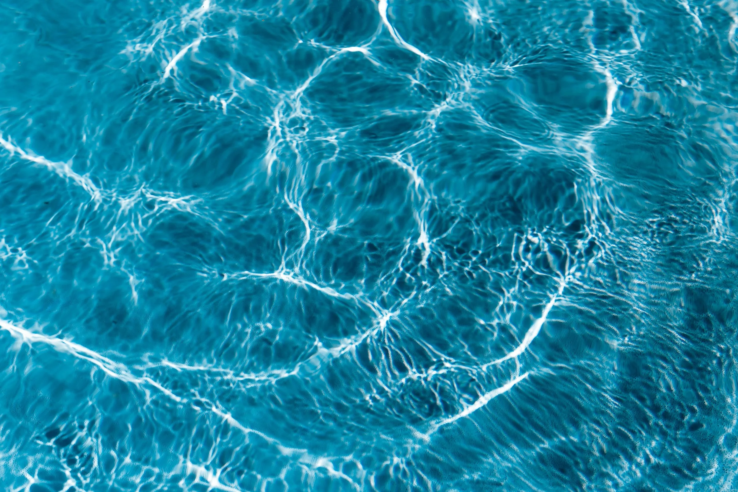 Sunlit ripples on clear blue water
